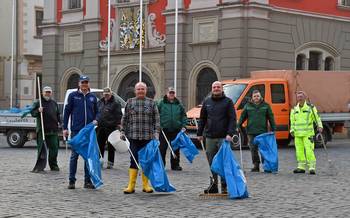 Gruppenbild mit Oberbürgermeister Knut Kreuch und weiteren Mitarbeitern vor dem Rathaus in Gotha. Sie halten Besen, Mülleimer und blaue Müllsäcke.