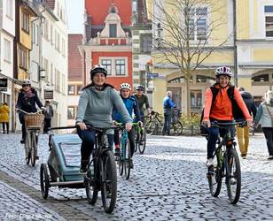 Mehrere Radfahrer und Radfahrerinnen fahren durch Gothas Innenstadt.