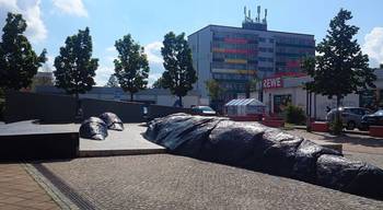 Laufbrunnen am Coburger Platz mit einem großen Wohnblock im Hintergrund.