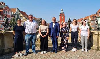 Gruppenfoto mit Rathaus im Hintergrund, öffnet größere Ansicht