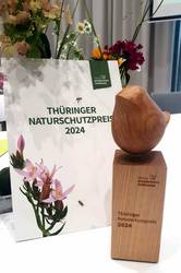 Der Thüringer Naturschutzpreis 2024 steht mit Blumen auf einem Tisch, öffnet größere Ansicht