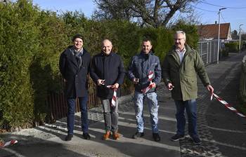 Vier Männer schneiden ein rot-weißes Absperrband zur Freigabe nach einer Sanierung durch, öffnet größerer Ansicht