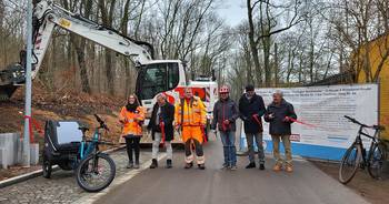 Ein Radweg wird für den Verkehr freigegeben, im Hintergrund steht ein Bagger, öffnet größere Ansicht