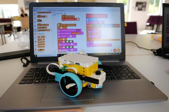 Ein LEGO-Roboter steht auf einem aufgeklappten Laptop, öffnet größere Ansicht