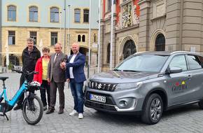 Oberbürgermeister Knut Kreuch und Mitarbeitende der Stadtverwaltung stehen mit einem neuem PKW und einem Lastenrad auf dem Hauptmarkt.