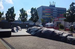 Laufbrunnen am Coburger Platz mit einem großen Wohnblock im Hintergrund.