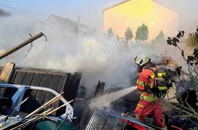 Ein Feuerwehrmann löscht einen Brand, öffnet größere Ansicht.