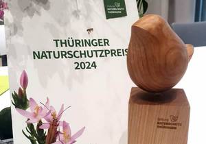 Der Thüringer Naturschutzpreis 2024 steht mit Blumen auf einem Tisch, öffnet größere Ansicht