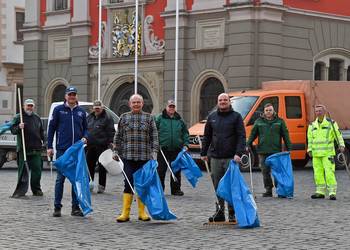 Gruppenbild mit Oberbürgermeister Knut Kreuch und weiteren Mitarbeitern vor dem Rathaus in Gotha. Sie halten Besen, Mülleimer und blaue Müllsäcke.