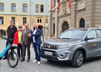 Oberbürgermeister Knut Kreuch und Mitarbeitende der Stadtverwaltung stehen mit einem neuem PKW und einem Lastenrad auf dem Hauptmarkt.