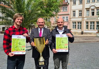 Oberbürgermeister Knut Kreuch, Beigeordnetet Peter Leinser un dMitarbeiter der Stadtvewraltung Markus Weise halten Plakate und den Residenzstadt-Pokal.