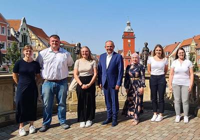 Gruppenfoto mit Rathaus im Hintergrund, öffnet größere Ansicht