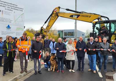 Ein Baustellenband wird durchggeschnitten und eine neu gebaute Straße freigegeben, öffnet größere Ansicht.