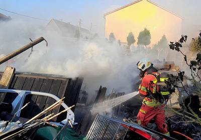 Ein Feuerwehrmann löscht einen Brand, öffnet größere Ansicht.