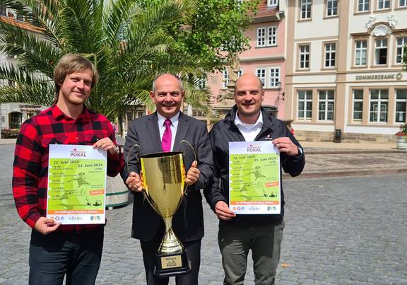 Oberbürgermeister Knut Kreuch, Beigeordnetet Peter Leinser un dMitarbeiter der Stadtvewraltung Markus Weise halten Plakate und den Residenzstadt-Pokal.