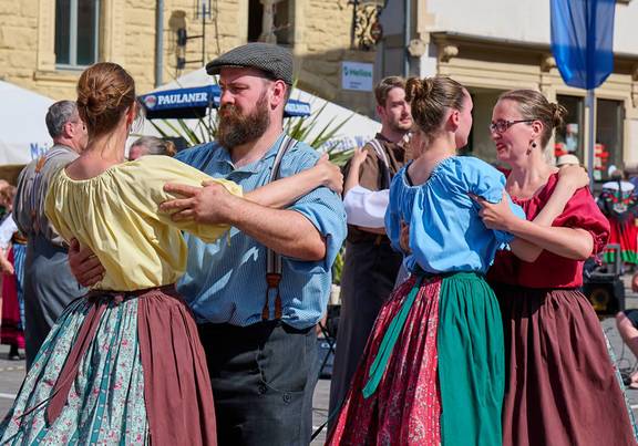 Tanzende Paare in bunter Tracht, öffnet größere Ansicht.