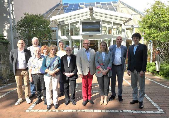 Oberbürgermeister Knut Kreuch, Bürgermeister Ulf Zillmann und Beigeordneter Peter Leisner mit internationalen Gästen in Gotha Gruppenbild vor einem Eingang, öffnet größeres Fenster